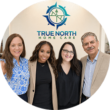 True North Home Care team standing in front of the company logo