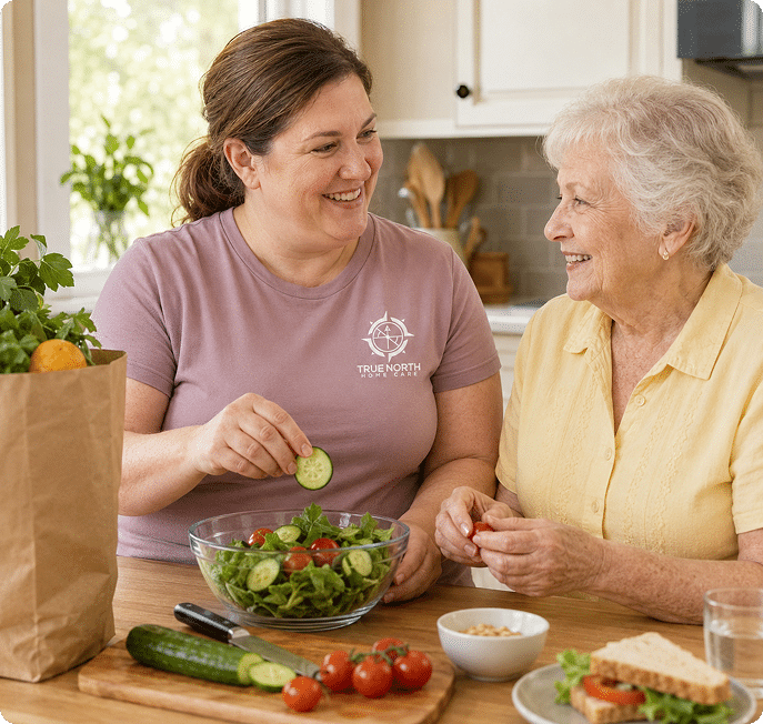 Caregiver and older woman preparing a salad together in a kitchen